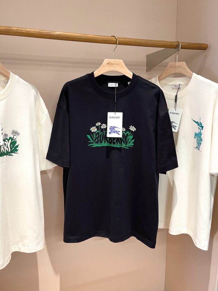Esposizione di T-shirt con ricami, grafiche colorate e stile moderno in negozio.