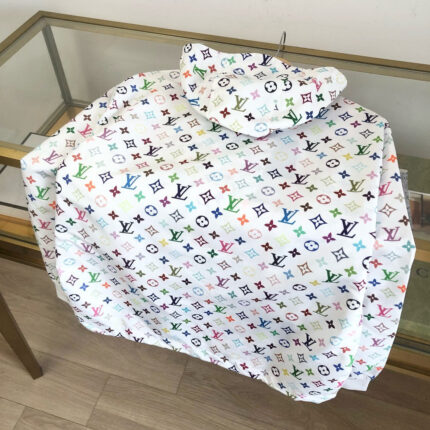 Impermeabile di lusso con motivi colorati su tavolo di vetro, stile moda contemporanea élégante.