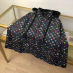 Poncho con cappuccio logo colorati, stile street e lusso, su tavolo in vetro e pavimento in legno