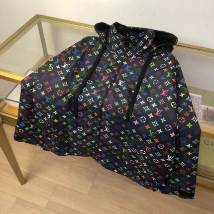 Poncho con cappuccio logo colorati, stile street e lusso, su tavolo in vetro e pavimento in legno