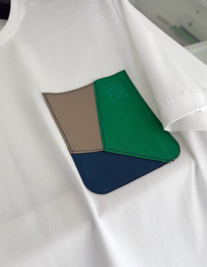 T-shirt bianco con pochette moderna multicolore, stile casual e design originale.
