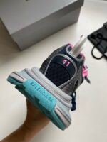 Sneaker sportiva con heel rosa, suola chunky azzurra e dettagli colorati, perfetta per stile casual.