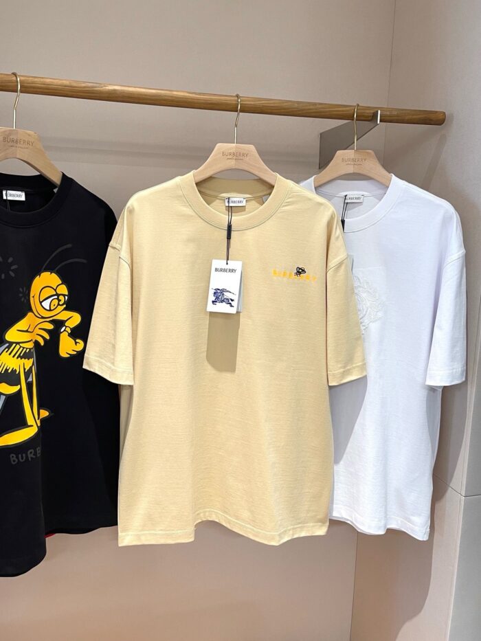 Vetrina con magliette casual colorate su mensile in legno, stile minimalista.