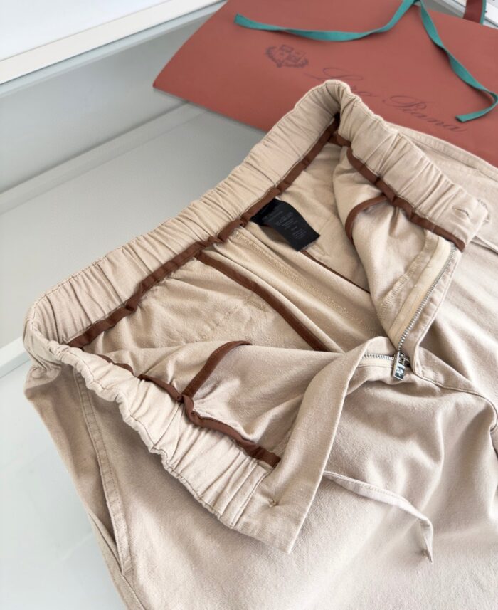 Pantaloni beige elasticizzati, comodi e stilosi, con dettaglio sulla cintura e confezione regalo elegante.