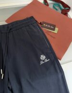 Pantaloni casual eleganti con borsa terracotta e dettagli ricamati, stile chic e confortevole.