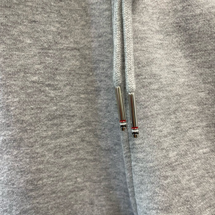 Felpa grigia con coulisse e aghetti metallici decorativi, stile casual e moderno.