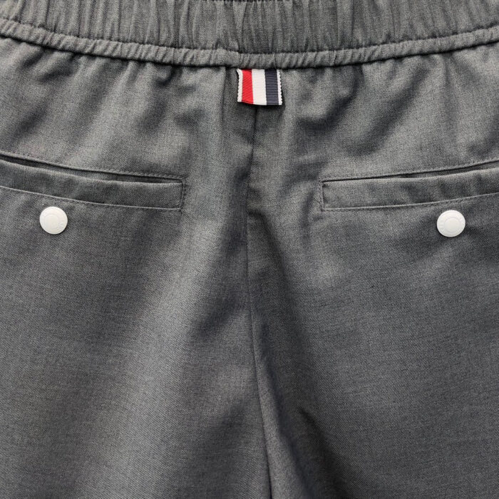 Pantaloni grigi comodi con elastico, tasche con bottoni e dettaglio tricolore.