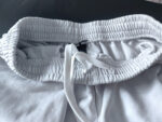 Shorts bianchi sportivi con cintura elastica e cordino regolabile per massimo comfort.