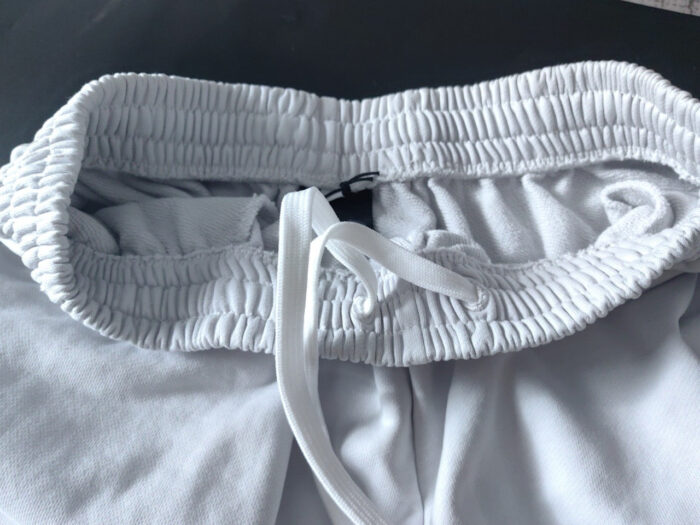 Shorts bianchi sportivi con cintura elastica e cordino regolabile per massimo comfort.