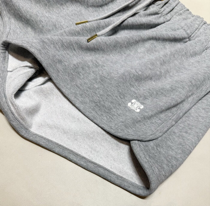Pantaloncini sportivi grigi con logo minimalista, elasticizzati e comodi per allenamento e relax.