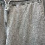 Pantaloni felpati grigi con cintura regolabile, tasche e stile casual e confortevole.