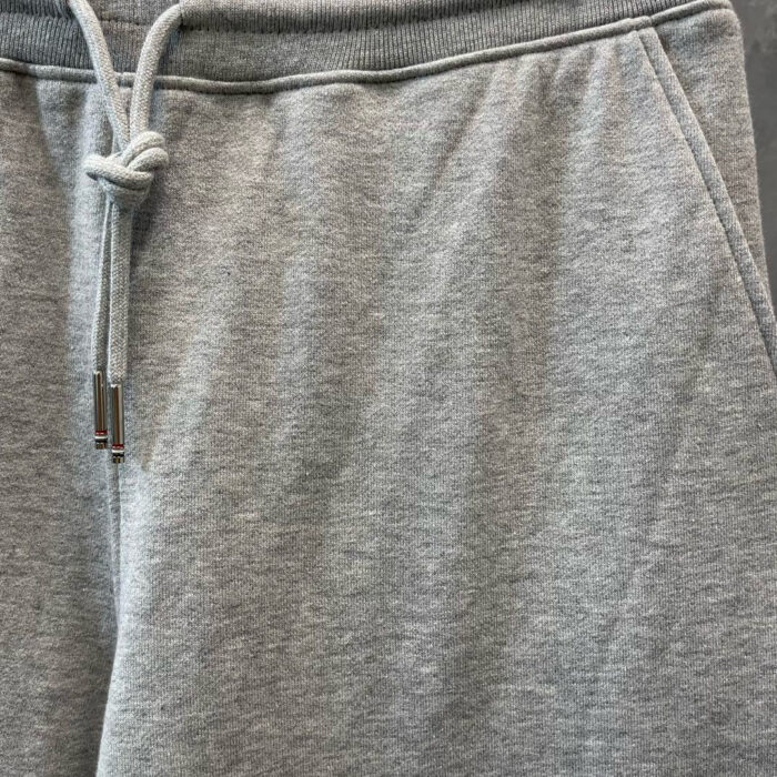 Pantaloni felpati grigi con cintura regolabile, tasche e stile casual e confortevole.