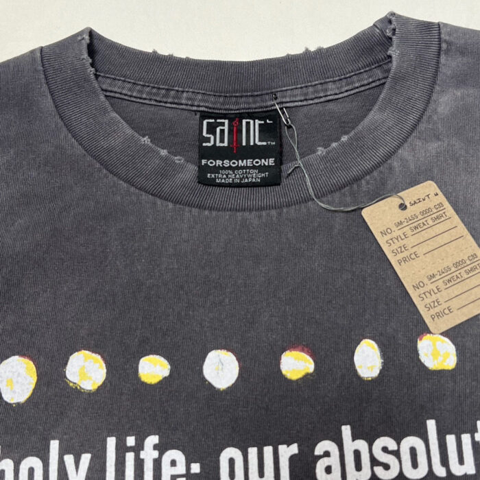 T-shirt grigia con cerchi colorati e messaggio bold, stile streetwear e design artistico.
