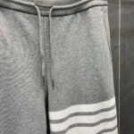 Pantaloni jogger grigi con strisce bianche, comodi e sportivi per relax e attività casual.