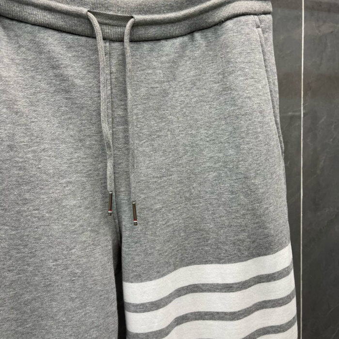 Pantaloni jogger grigi con strisce bianche, comodi e sportivi per relax e attività casual.