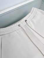 Pantaloni jogger bianchi, elastici, con cordino e dettagli eleganti in tessuto morbido.