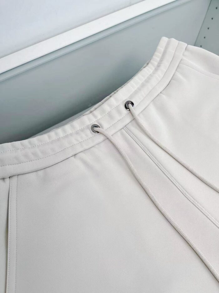 Pantaloni jogger bianchi, elastici, con cordino e dettagli eleganti in tessuto morbido.