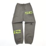 Pantaloni jogger grigi con grafica neon 52 e ragno stilizzato, ideale per stile casual e streetwear.