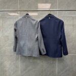 Blazer grigia a quadri e navy classico: stile elegante e professionale su supporto metallico.