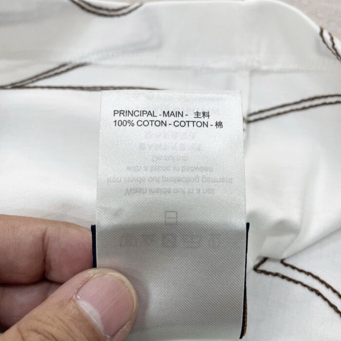 Etichetta in cotone con istruzioni di cura multilingue per abbigliamento di qualità