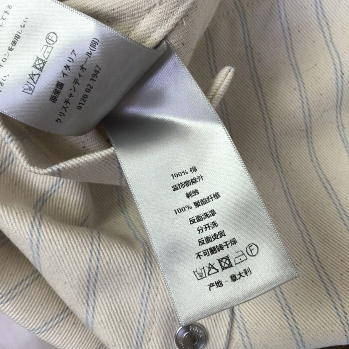 Etichetta in satin con istruzioni di lavaggio su camicia a strisce in cotone.