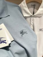 Polo shirt azzurra e bianca con logo ricamato, stile casual e qualità premium.