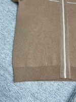 Maglione beige in maglia con zip, dettagli sportivi e tessuto morbido e confortevole.