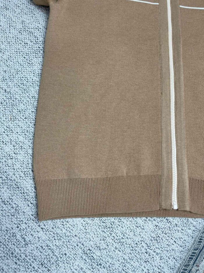 Maglione beige in maglia con zip, dettagli sportivi e tessuto morbido e confortevole.
