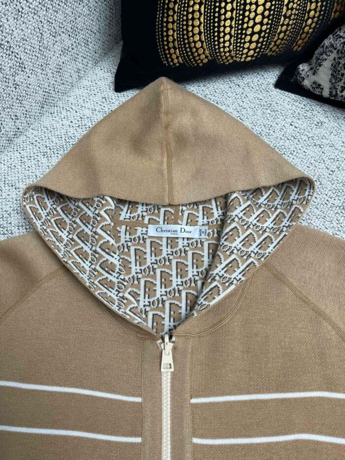 Felpa beige con cappuccio aperto, dettagli geometrici interni e strisce sportive eleganti.