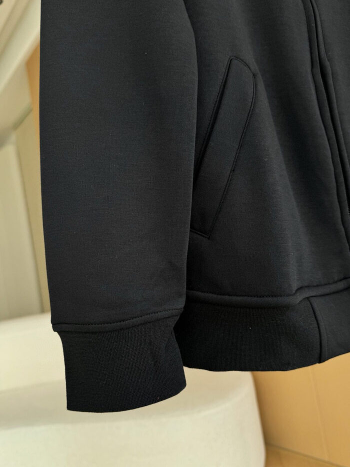Felpa nera minimalista con polsini elasticizzati e tasche frontali pratiche, perfetta per il relax quotidiano.