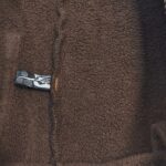 Fleece marrone morbido con etichetta, perfetto per abbigliamento confortevole e casual.