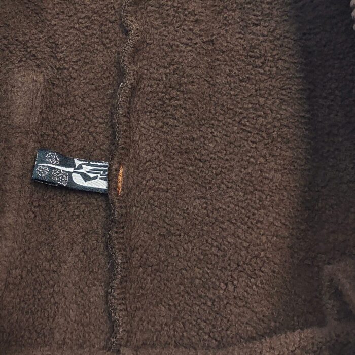 Fleece marrone morbido con etichetta, perfetto per abbigliamento confortevole e casual.