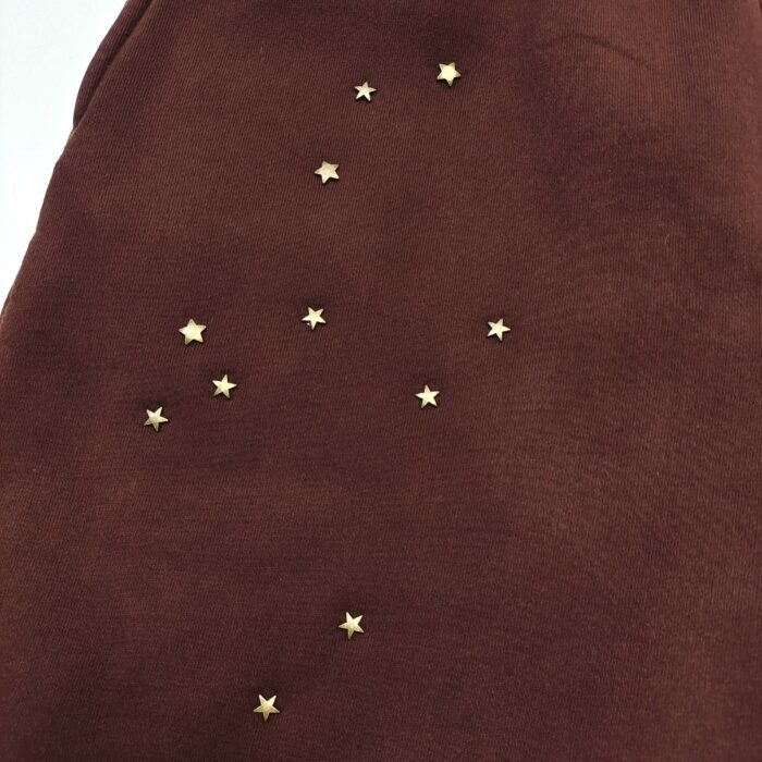 Maglietta marrone con stelle dorate, stile celestiale e dettagli eleganti, perfetta per l’autunno.