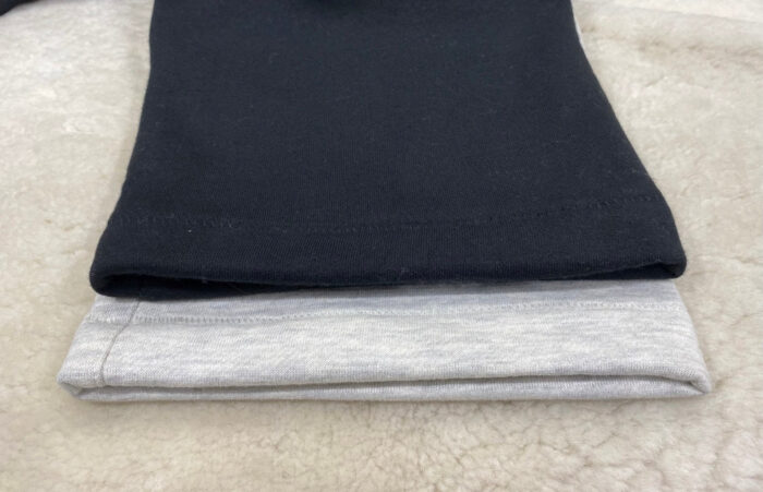 Magliette casual nere e grigie su superficie morbida, perfette per look confortevoli e semplici.