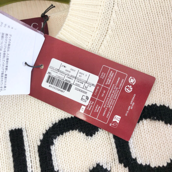 Maglione in lana crema con logo nero e etichette di marca, nuovo e di alta qualità.