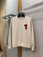 Felpa beige con fiocco rosso, stile casual ed elegante, perfetta per ogni occasione.