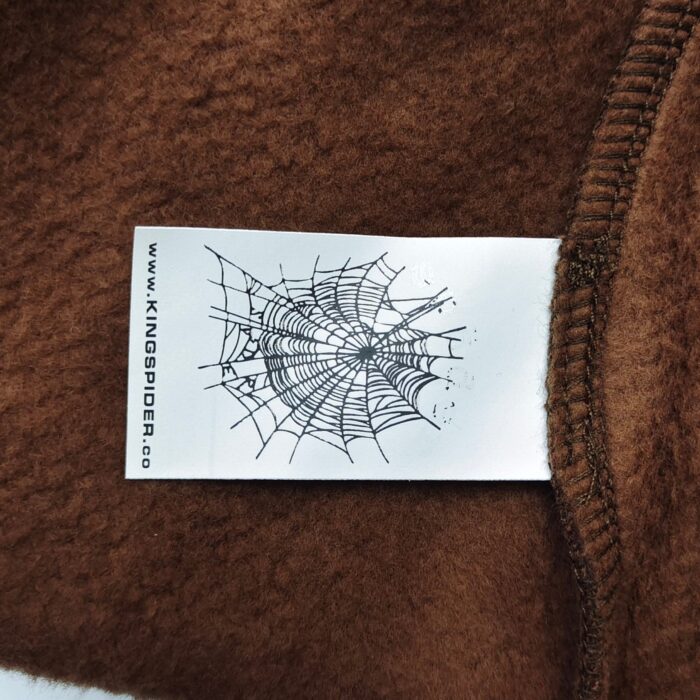 Etichetta di abbigliamento con web di ragno e logo Kingspider su tessuto caldo e morbido.