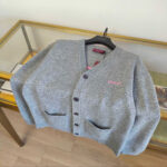 Cardigan grigia con tasche a contrasto e logo GUESS, stile moderno e raffinato.