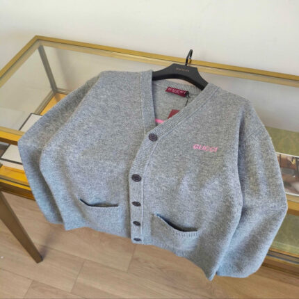 Cardigan grigia con tasche a contrasto e logo GUESS, stile moderno e raffinato.