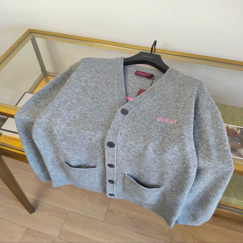Cardigan grigia con tasche a contrasto e logo GUESS, stile moderno e raffinato.