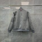 Giacca sportiva grigia minimalista con strisce sulle maniche e colle alto, vista posteriore.