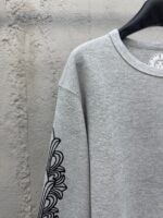 Felpa oversized grigia con dettagli grafici neri e stile urbano, perfetta per un look casual.