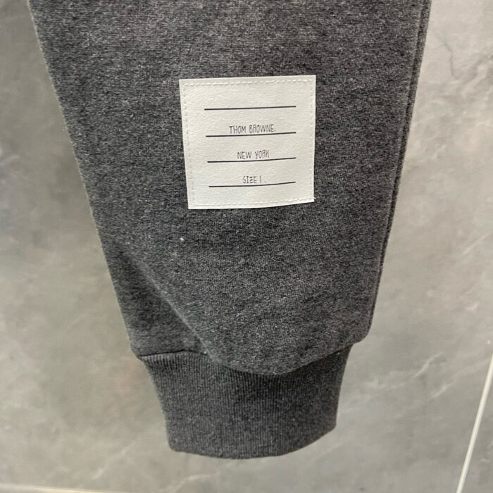 Polsino grigio con etichetta con dettagli su cura e composizione del tessuto.