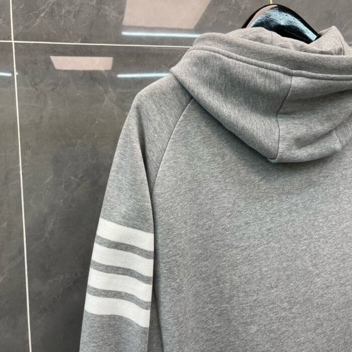 Felpa grigia minimalista con strisce bianche sulle maniche, perfetta per outfit casual e sportivi.