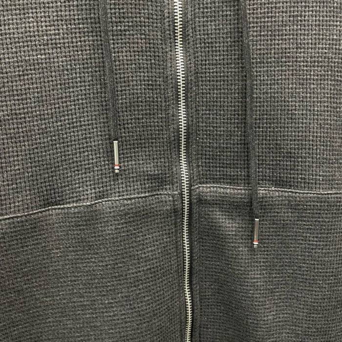 Felpa grigia con zip, tessuto testurizzato, stile casual, comfort e design moderno.