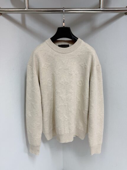 Maglione beige morbido con collo tondo, maniche spacerate, su supporto moderno, ideale per l’autunno.