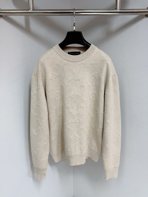 Maglione beige morbido con collo tondo, maniche spacerate, su supporto moderno, ideale per l’autunno.