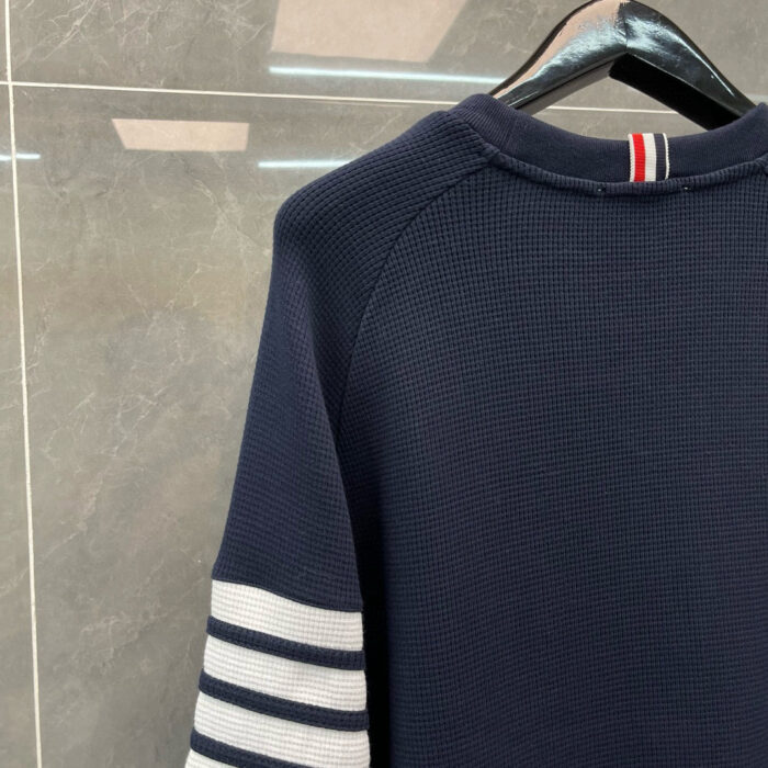 Maglione navy a righe bianche stile vintage in cotone, look casual e sportivo.