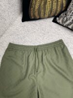 Pantaloni jogger oliva con cuscini decorativi eleganti per uno stile casual sofisticato.