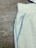Pantaloni casual bianco con dettagli in blu e tessuto morbido e testurizzato.